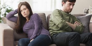 Caucasian couple arguing on sofa