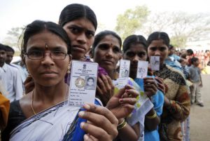 Women display their voters identity cards and stand in queue to cast their votes at a polling station on the outskirts of Hyderabad, India, Thursday, April 16, 2009. Hundreds of thousands of Indians went to polling stations Thursday to start the world's biggest democratic elections, a month-long process expected to yield no clear winner to lead India as it grapples with global economic malaise. (AP Photo/Mahesh Kumar A.)