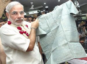 prime_minister_narendra_modi_looking_at_khadi_clothes_at_a_store