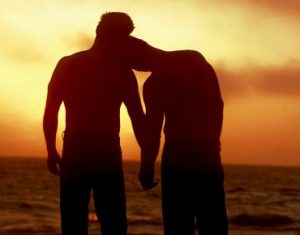 two-men-on-the-beach-at-sunset-holding-hands-370x290